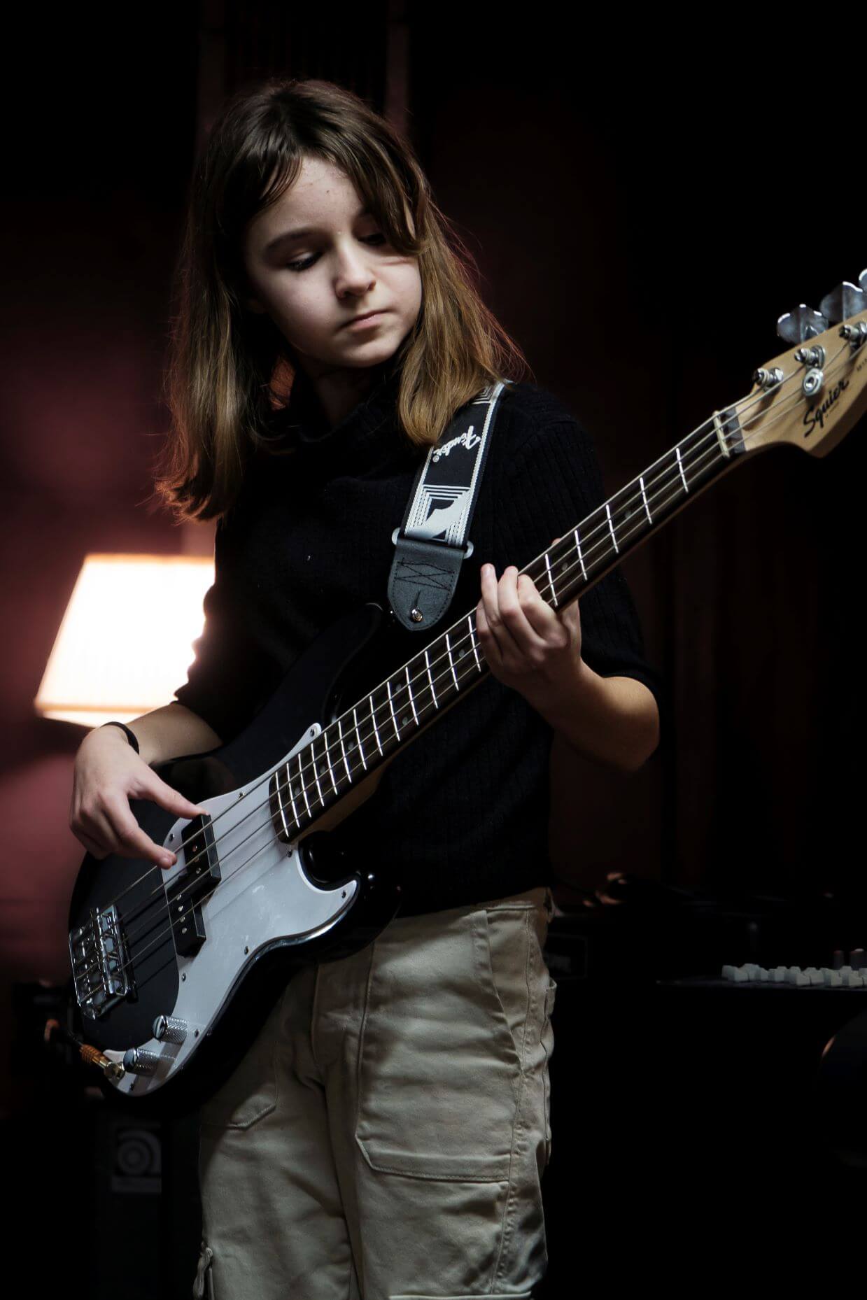 Jeune enfant jouant de la basse lors d'un spectacle organisé par l'association Améthyste.