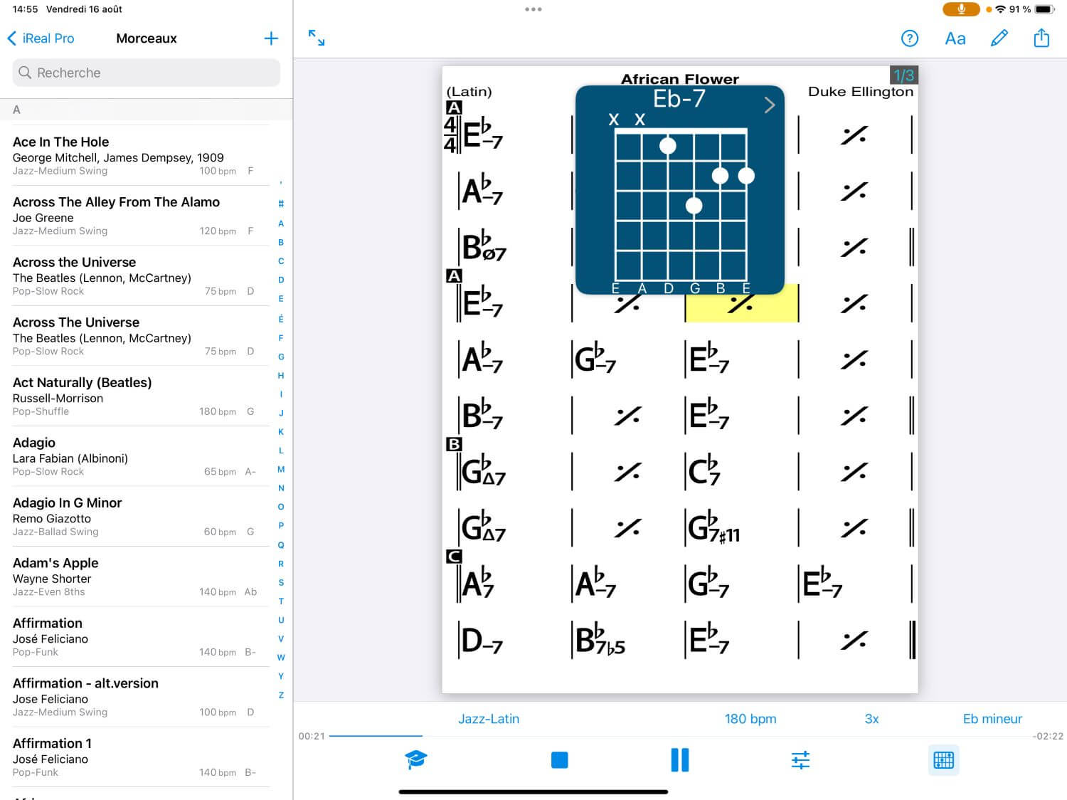 Gros plan sur un casque d'écoute avec en arrière-plan un écran d'ordinateur affichant le logiciel GarageBand, illustrant un environnement de création musicale numérique.